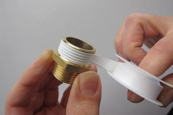 PTFE plumber's tape wrapped around threaded pipe fittings before assembly to help prevent leaks at threaded connections.